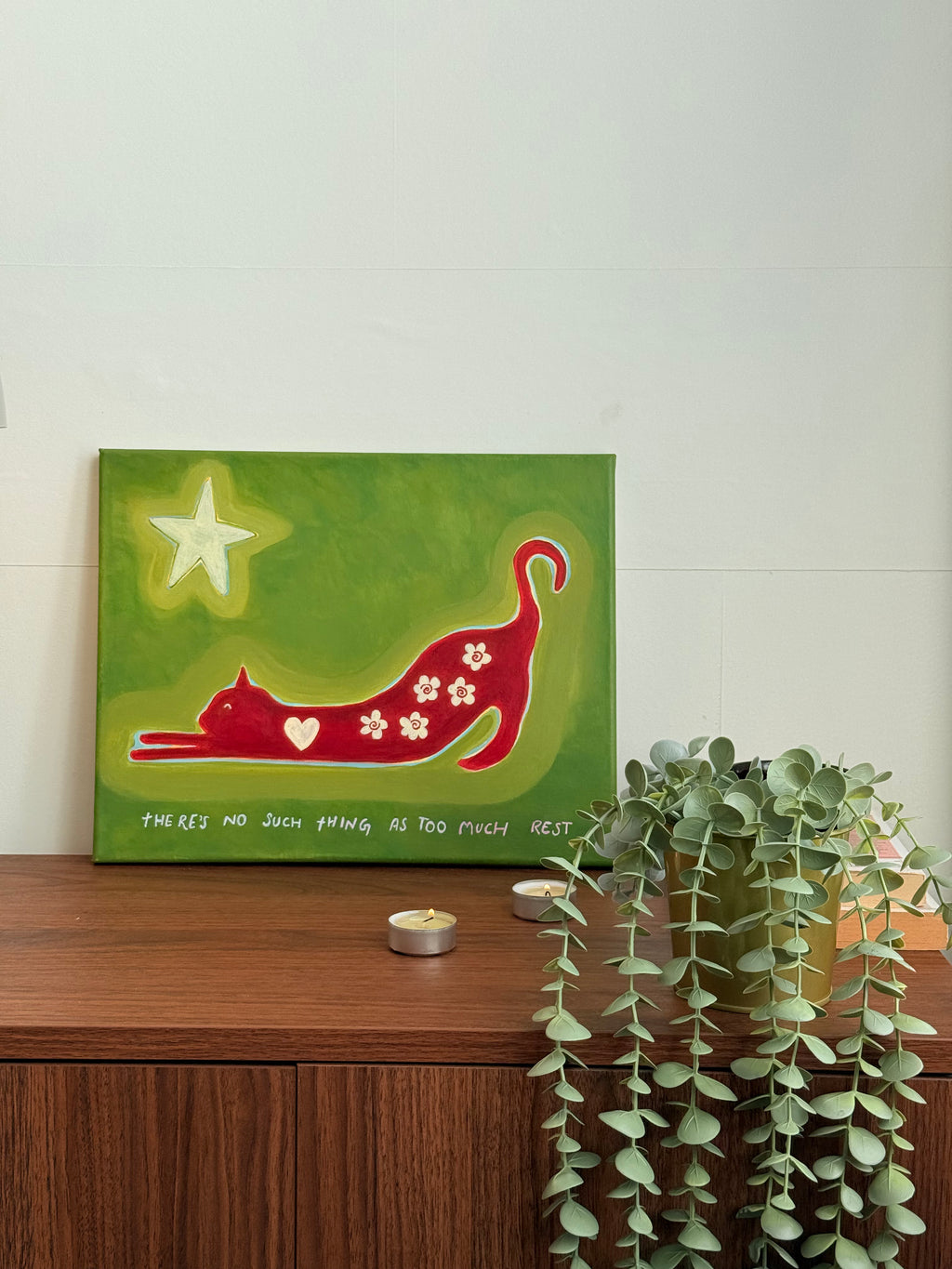 Close-up of red floral cat and cream star on an olive green original canvas